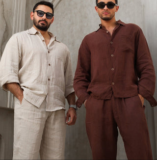 Two men wearing Everseason linen outfits standing against a gray wall.