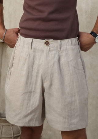 Person wearing Everseason beige shorts and a brown shirt against a neutral background