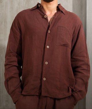 Man wearing Everseason brown shirt and sunglasses against a gray wall