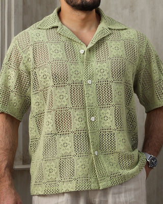 Man wearing a mint green crochet  textured shirt and  a neutral background