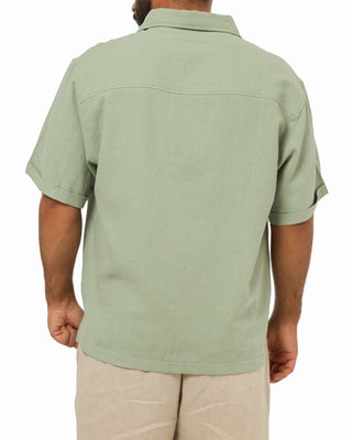 Person wearing an everseason light green polo shirt on a white background